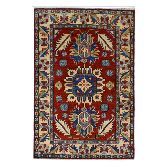 Full view of Afghan Kazak hand-knotted wool rug with red field, geometric medallions and cream border, 156 x 100 cm