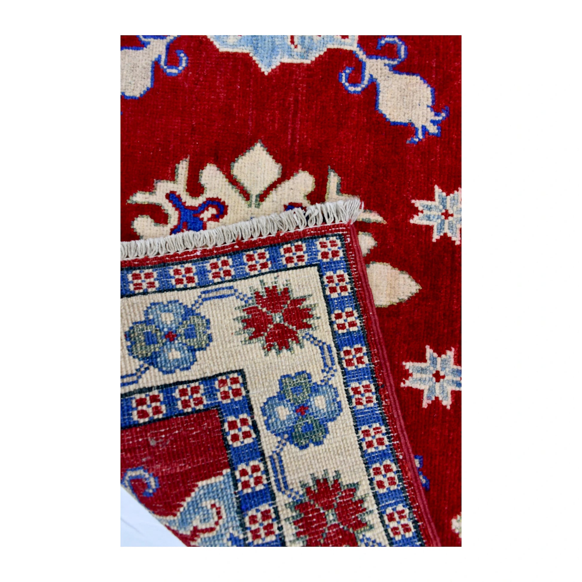 Folded corner reverse-weave detail of Afghan Kazak hand-knotted wool rug showing the back structure, pattern and weave