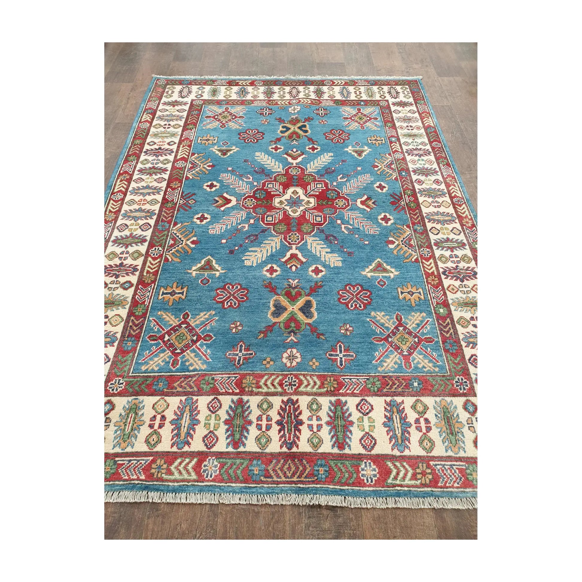 Angled field view of Afghan Kazak hand-knotted rug showing medallion and detailed border