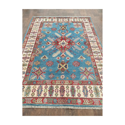 Angled field view of Afghan Kazak hand-knotted rug showing medallion and detailed border
