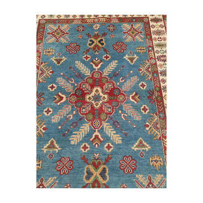 Central medallion detail of Afghan Kazak wool rug with geometric motifs on blue field