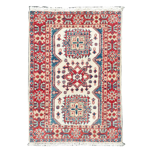 Full view of Afghan Kazak hand-knotted wool rug with cream field, muted red border, teal accents and geometric medallions, 86 x 62 cm