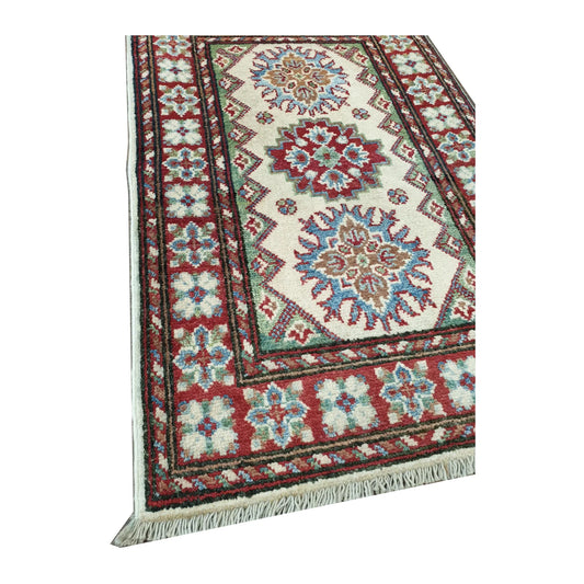 Close-up of Afghan Kazak wool rug showing red blue border detail, fringe edge and hand-knotted pile texture, 88 x 58 cm