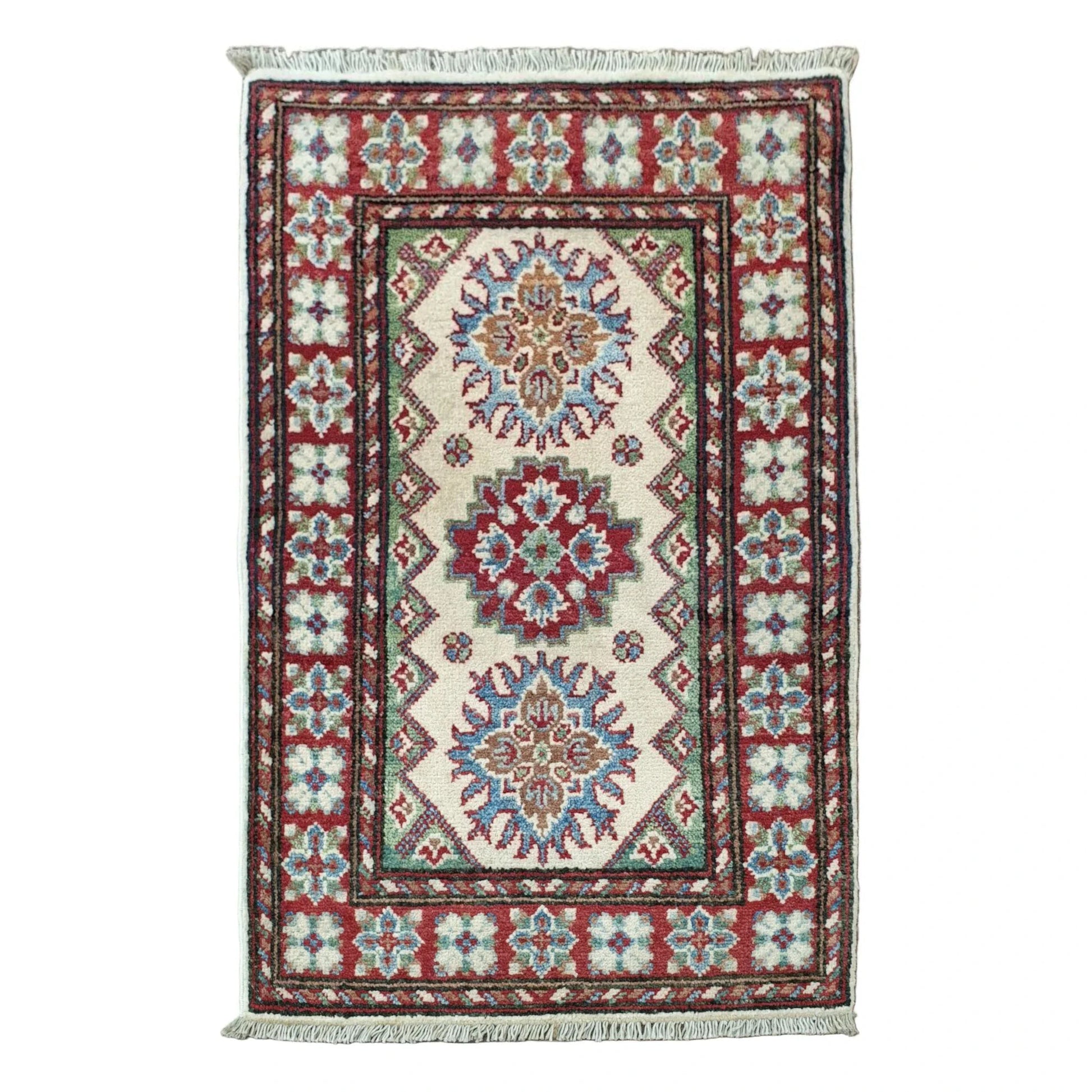 Full view of Afghan Kazak hand-knotted wool rug with cream field, geometric medallions and red blue border, 88 x 58 cm