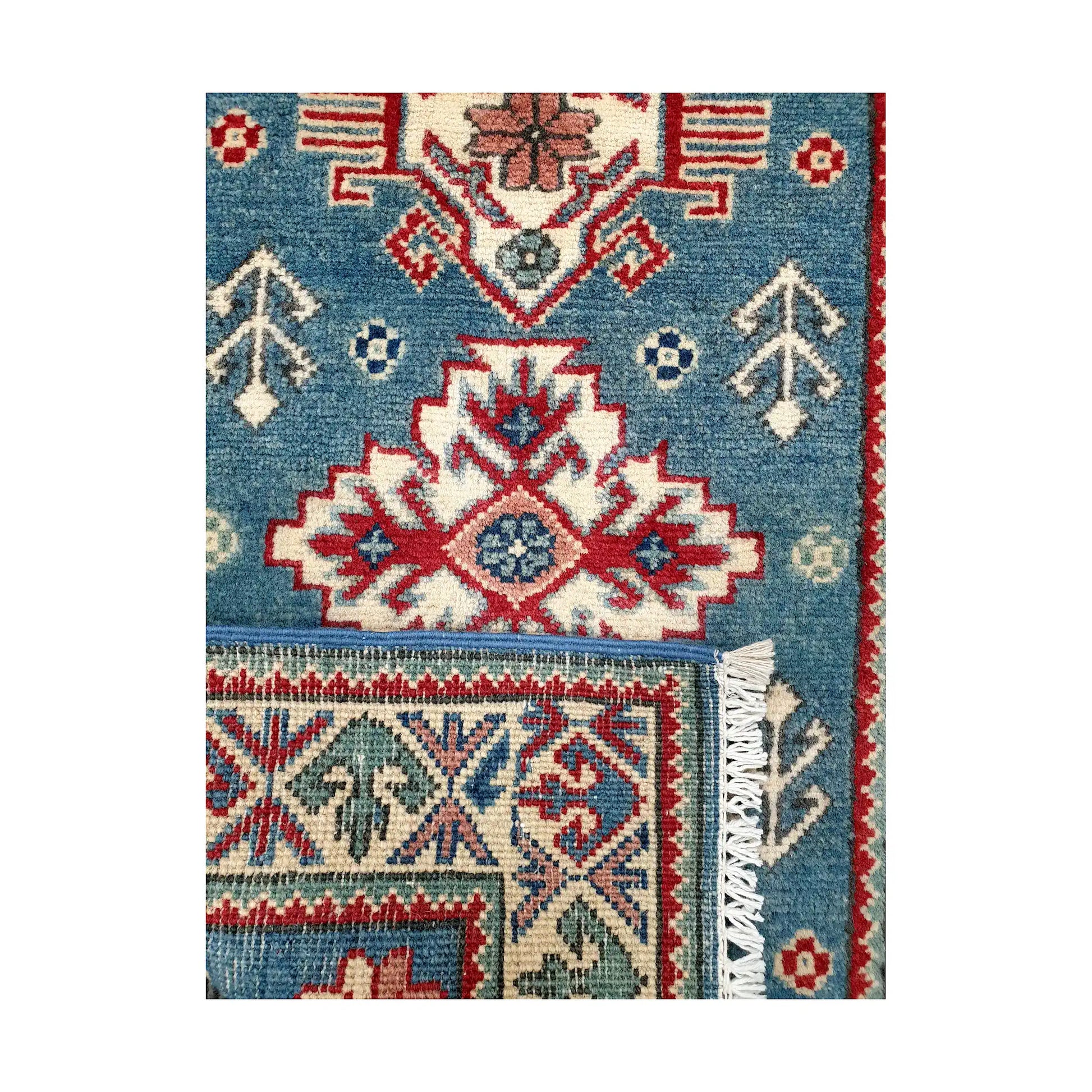 Folded corner reverse-weave detail of Afghan Kazak hand-knotted wool rug showing back structure, blue field, border pattern and fringe
