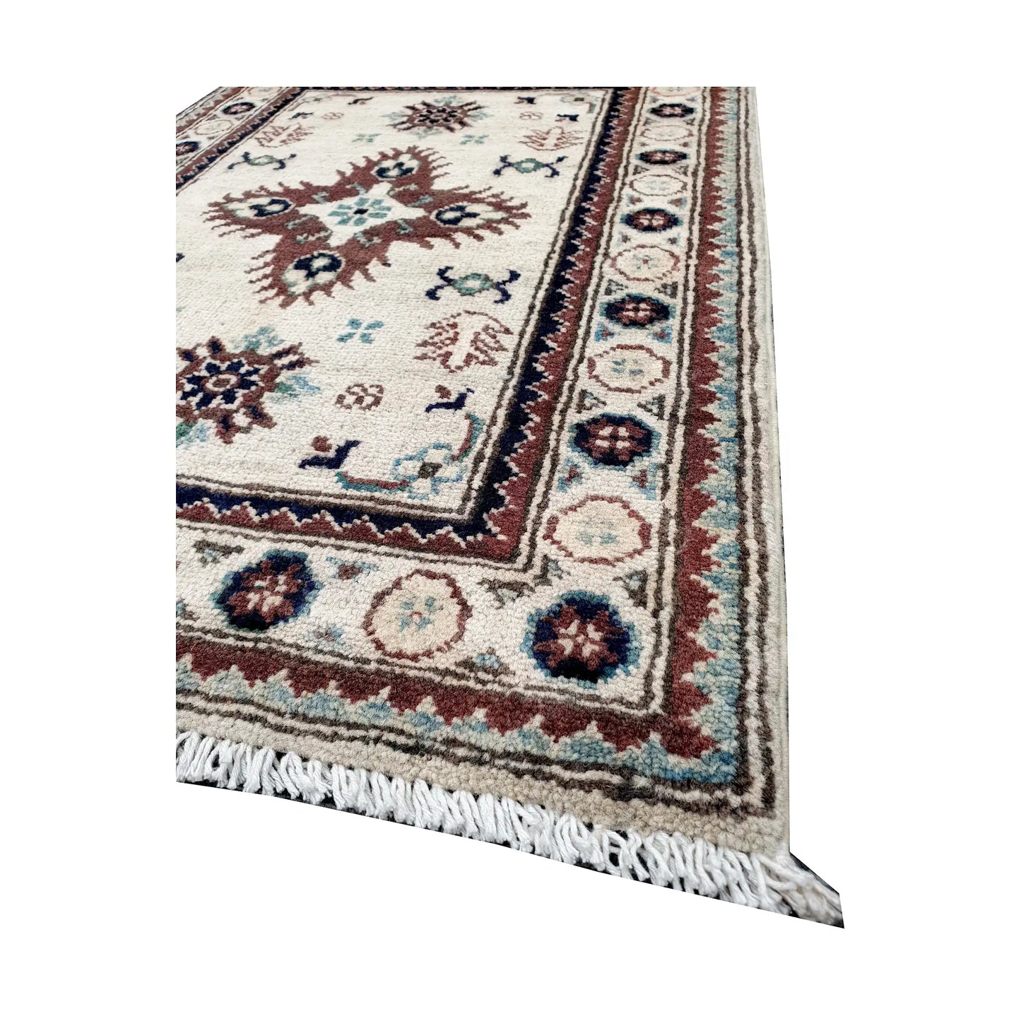 Angled corner and fringe view of Afghan Kazak wool rug showing ivory field, muted border detail and light fringe