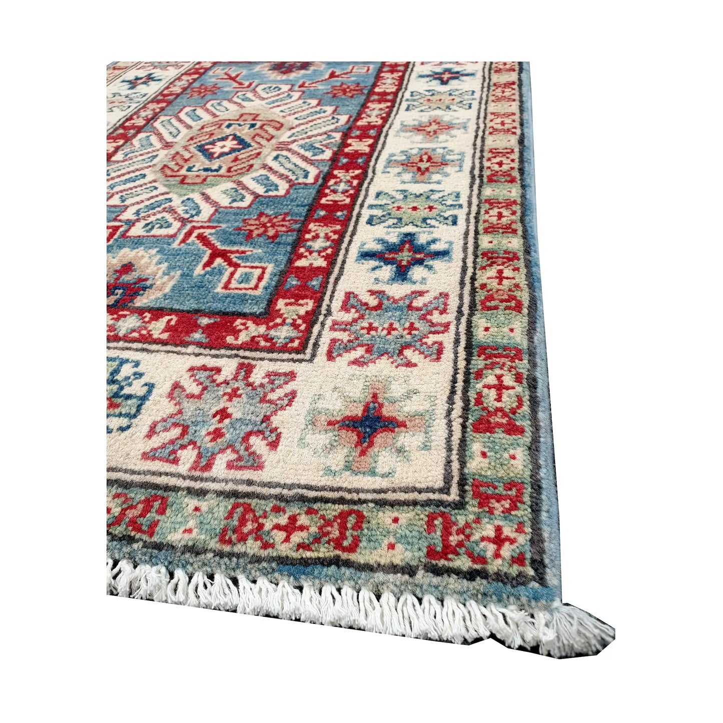 Angled corner and fringe view of Afghan Kazak wool rug showing blue field, off-white border, red accents and light fringe