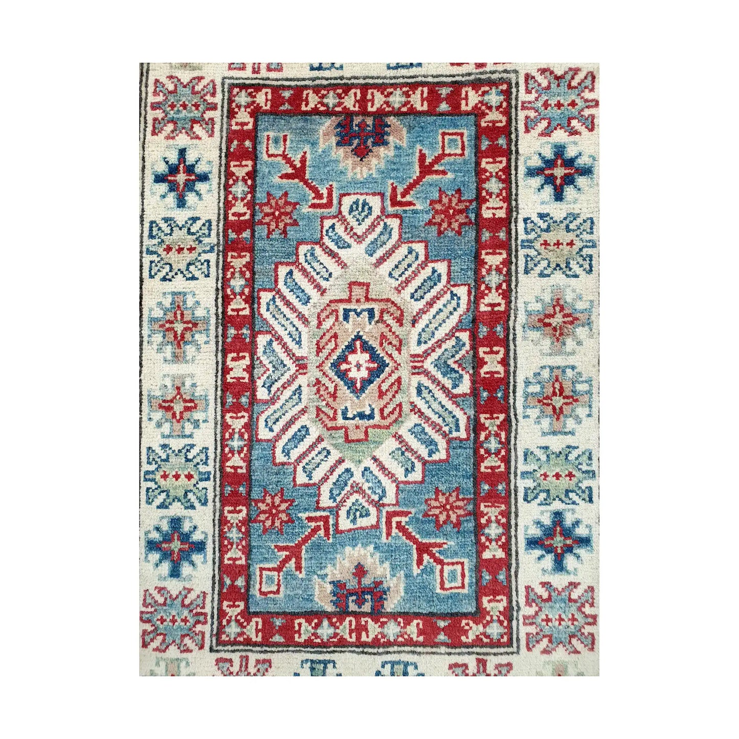 Angled corner and fringe view of Afghan Kazak wool rug showing blue field, off-white border, red accents and light fringe