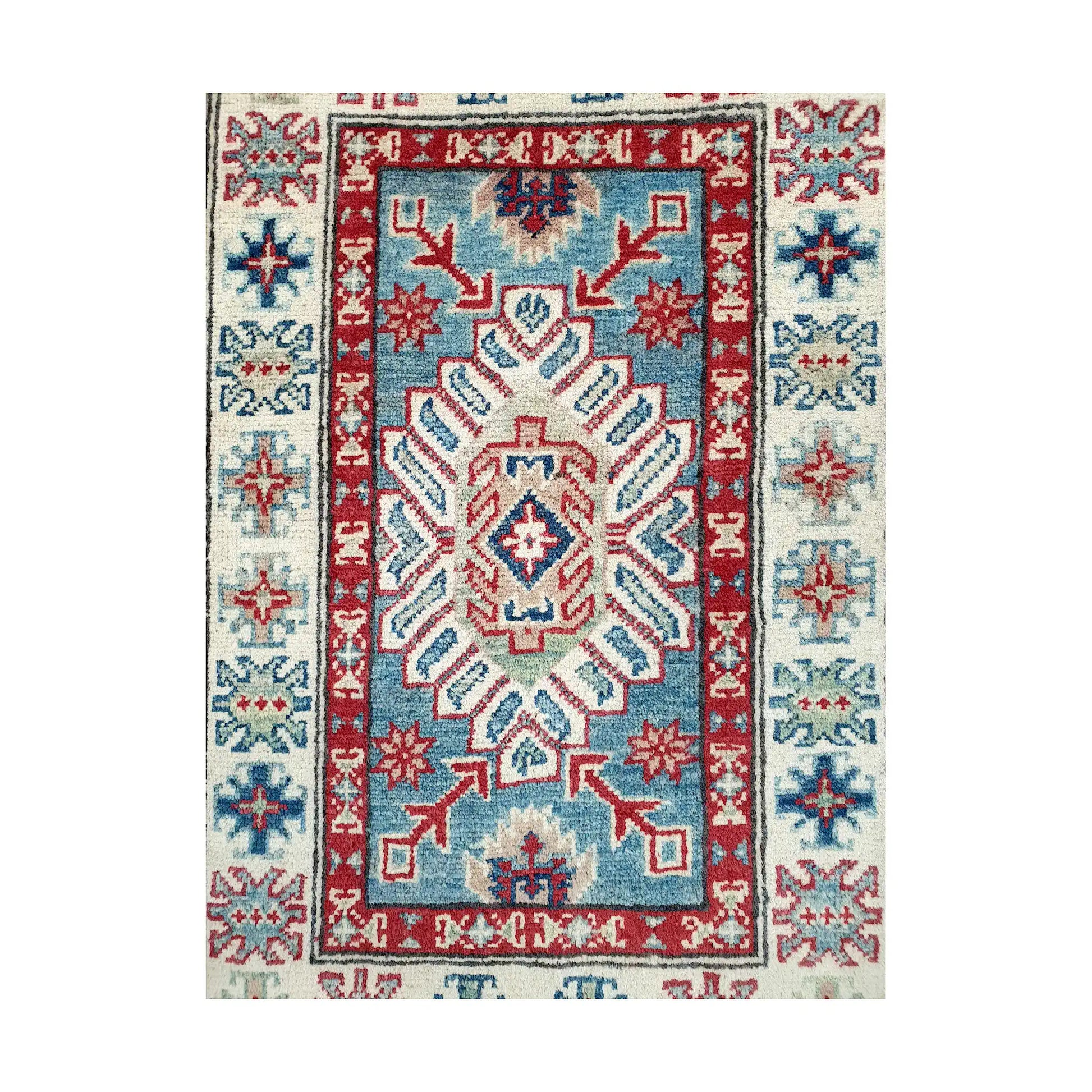 Angled corner and fringe view of Afghan Kazak wool rug showing blue field, off-white border, red accents and light fringe