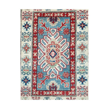 Angled corner and fringe view of Afghan Kazak wool rug showing blue field, off-white border, red accents and light fringe