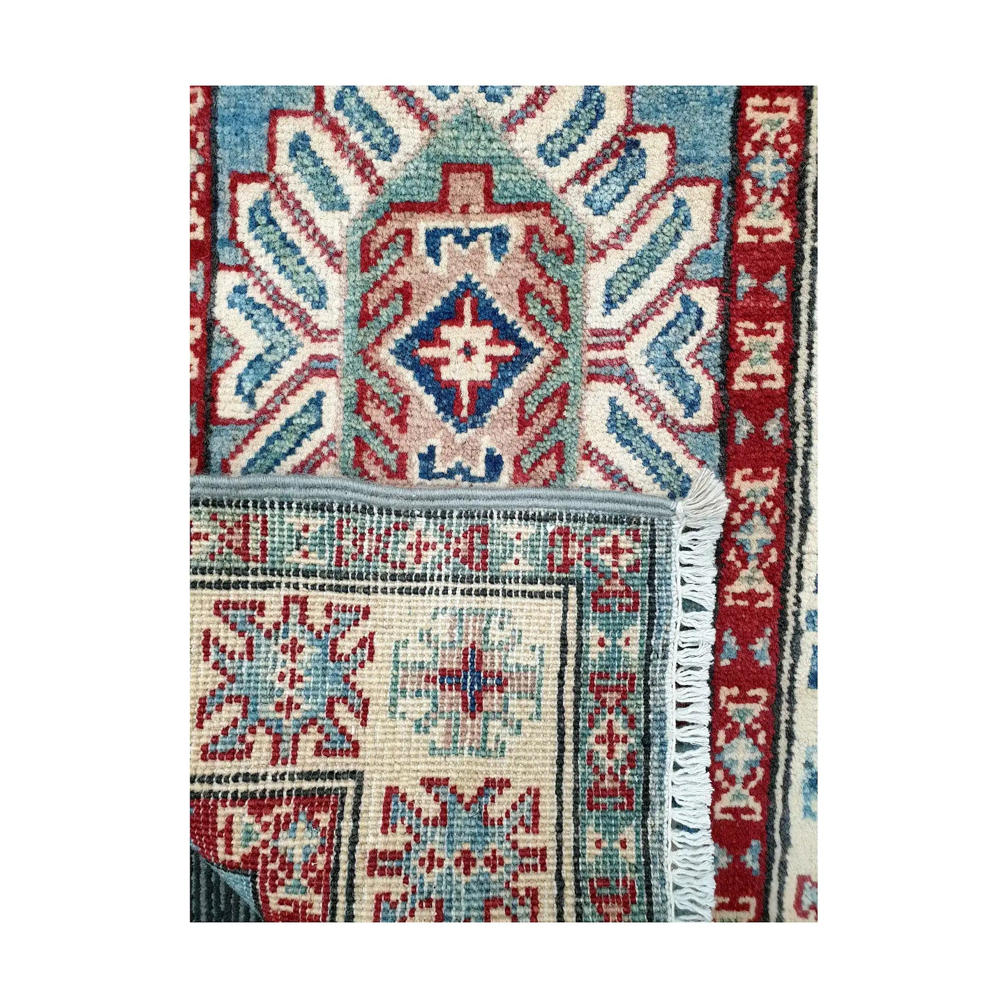 Folded corner reverse-weave detail of Afghan Kazak hand-knotted wool rug showing back structure, border pattern, fringe and weave