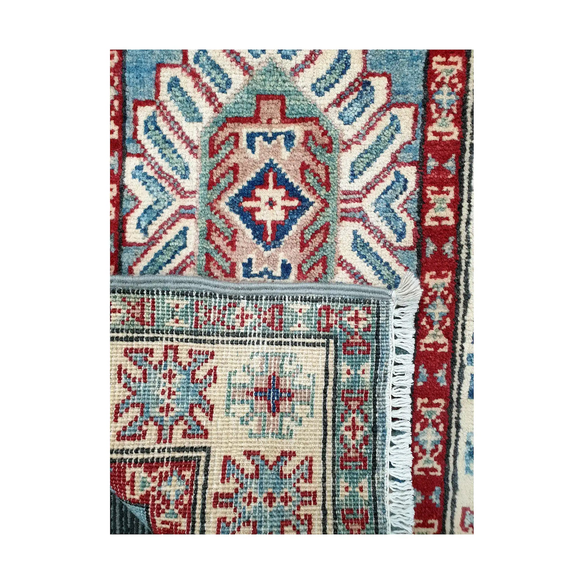 Folded corner reverse-weave detail of Afghan Kazak hand-knotted wool rug showing back structure, border pattern, fringe and weave