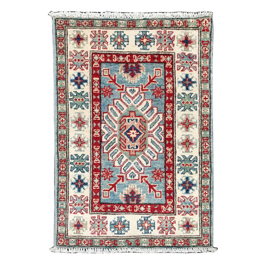 Full view of Afghan Kazak hand-knotted wool rug with blue field, off-white border, red accents and central geometric motif, 91 x 61 cm
