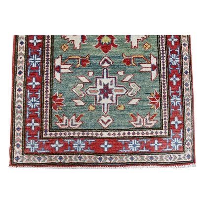 End-field detail of Kazak runner showing a cross-shaped medallion and layered red, ivory and pale-blue borders