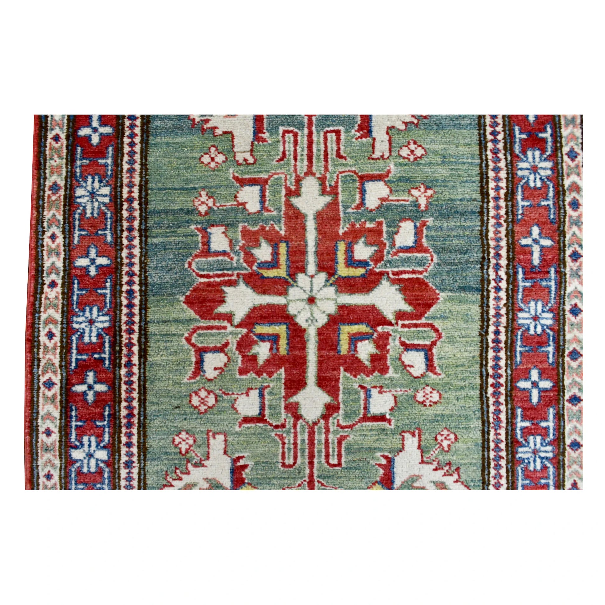 Close-up of a large red geometric medallion on the sage-green field of the Afghan Kazak runner