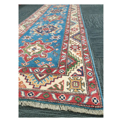 Angled detail of Kazak runner showing border motifs, fringe, and hand-knotted wool texture, 250 x 88 cm