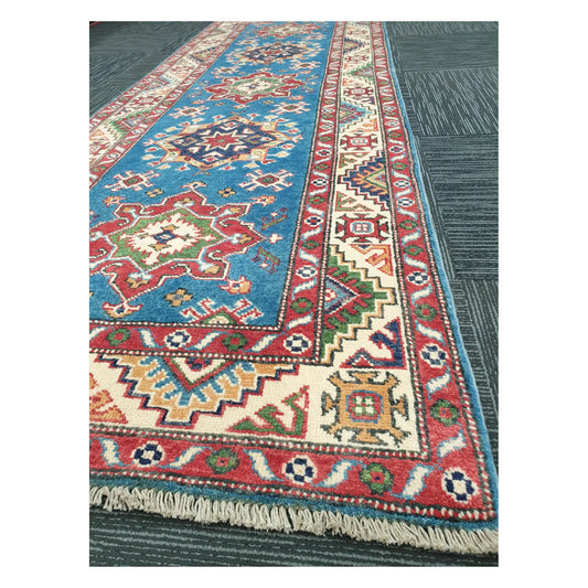 Angled detail of Kazak runner showing border motifs, fringe, and hand-knotted wool texture, 250 x 88 cm