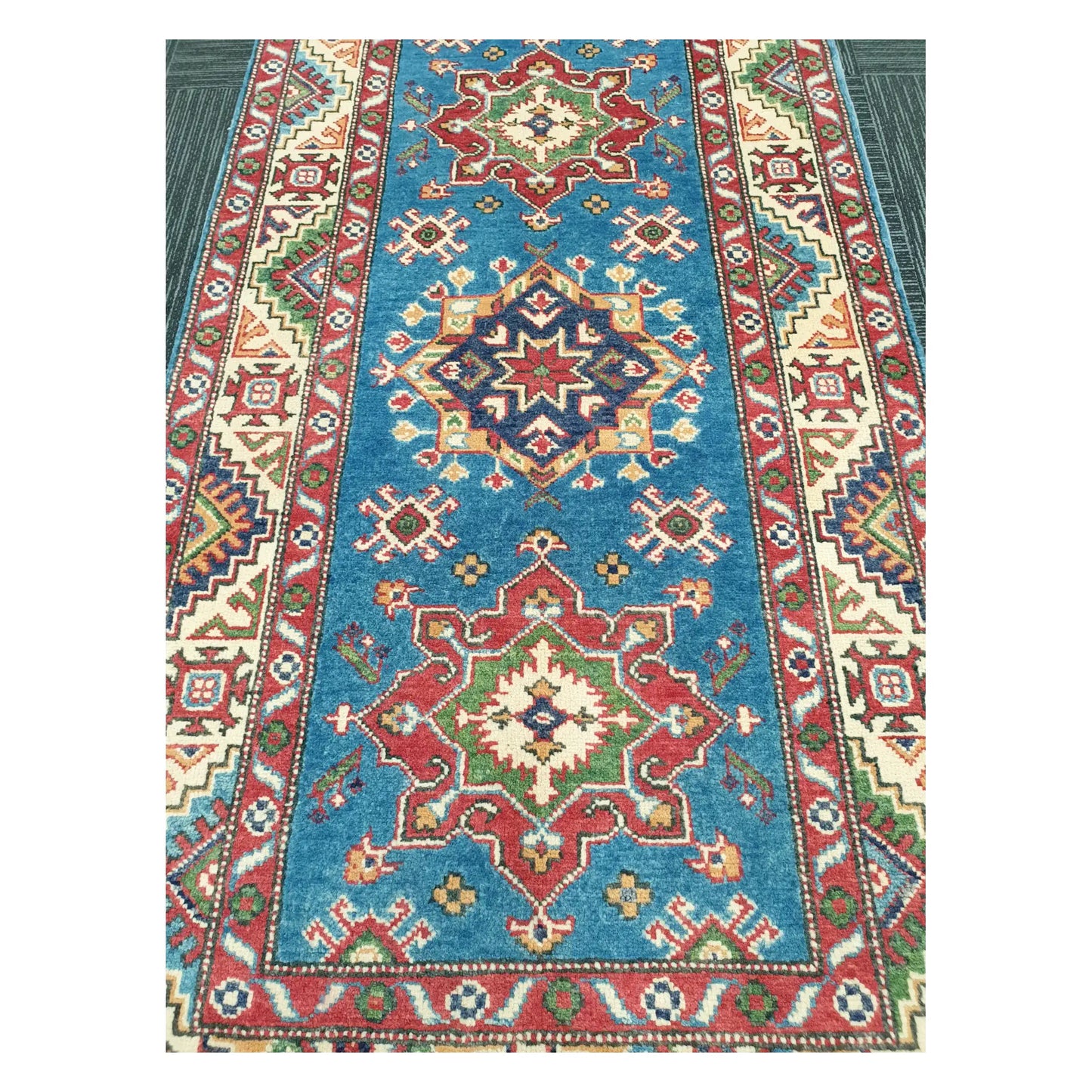Close-up of Afghan Kazak runner with sky blue ground and multicolour geometric medallion pattern, 250 x 88 cm