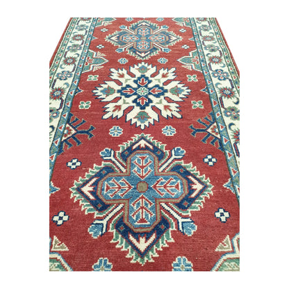 Close-up of Afghan Kazak runner rug medallion pattern with red, cream, blue and light green geometric detail