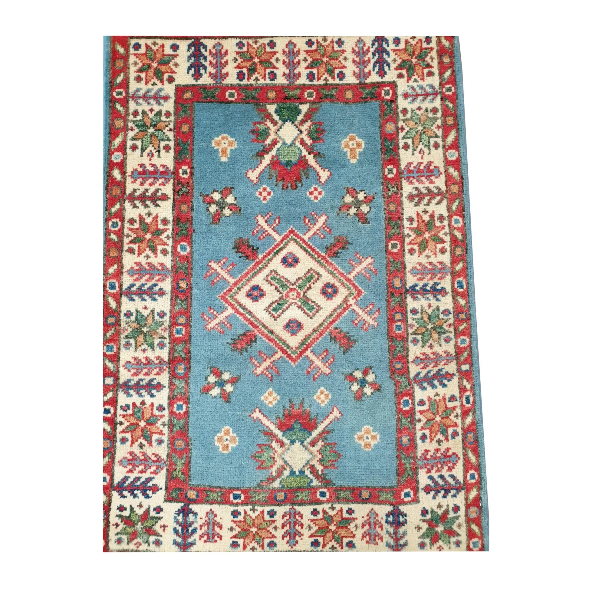 Close-up of Afghan Kazak wool rug showing the central diamond medallion, blue field and layered red and ivory border