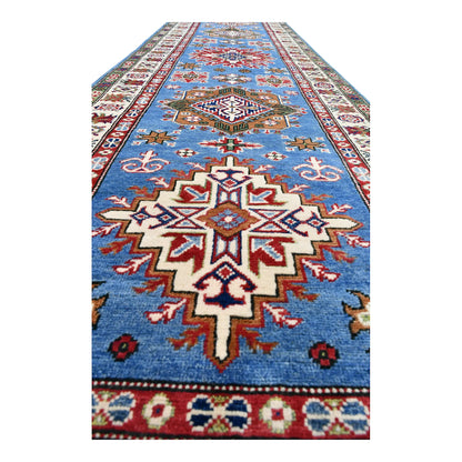 Angled close-up of Afghan Kazak runner showing a stepped star medallion and surrounding geometric motifs
