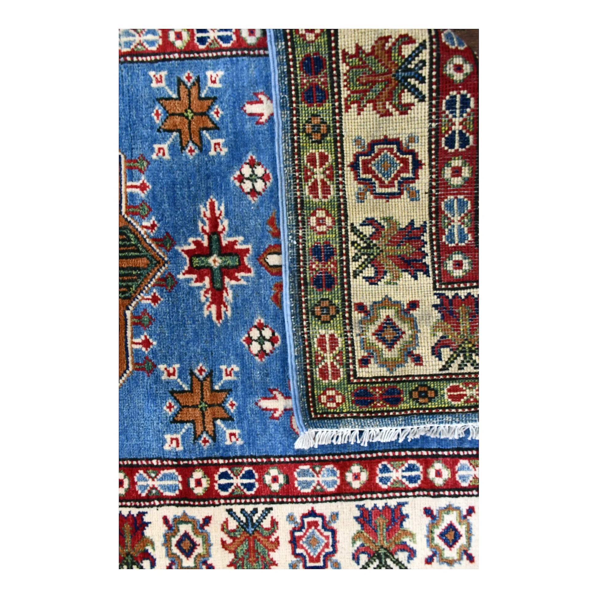 Folded corner of Afghan Kazak runner showing the patterned face, reverse weave and edge finishing