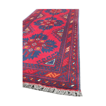 Angled corner and fringe view of Afghan Khal Mohammadi wool rug showing deep red field, dark blue motifs, border detail and light fringe