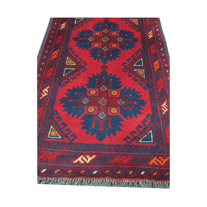 Geometric medallion and field detail of Afghan Khal Mohammadi hand-knotted rug showing dark blue motifs on a deep red ground
