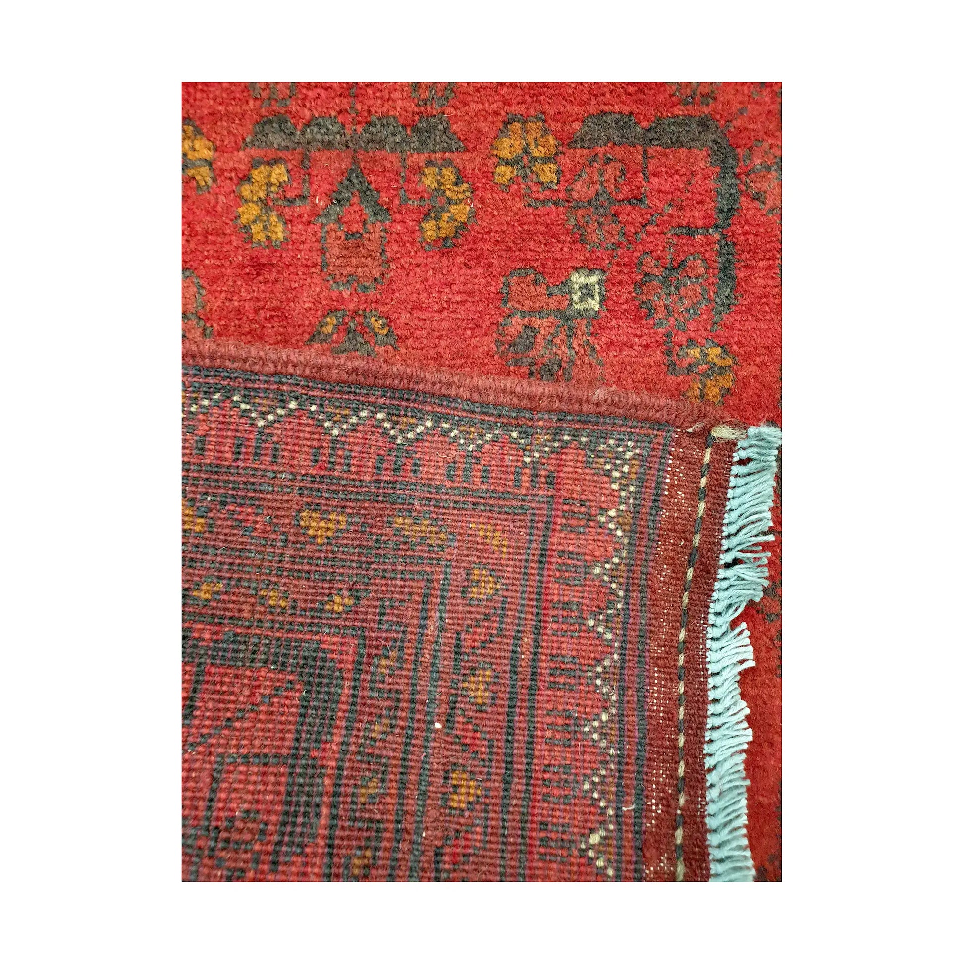 Folded corner reverse-weave detail of Afghan Khal Mohammadi hand-knotted wool rug showing back structure, fringe, border pattern and weave