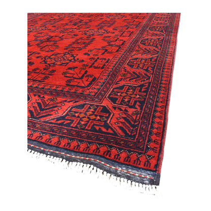 Angled view of Khal Mohammadi wool rug showing its rich red field, dark navy borders and pale fringe