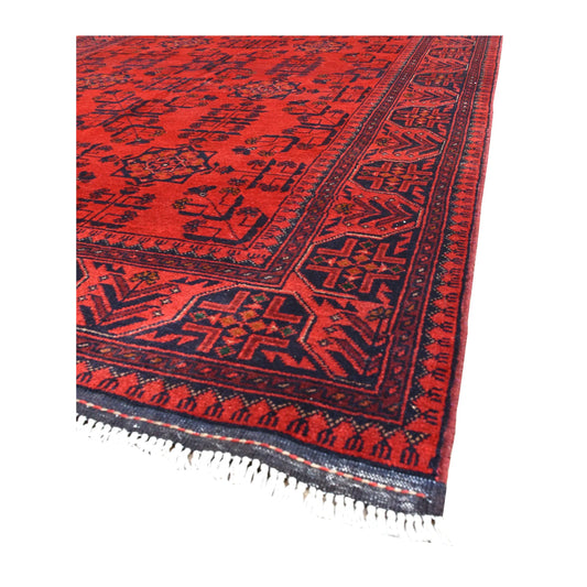 Angled view of Khal Mohammadi wool rug showing its rich red field, dark navy borders and pale fringe