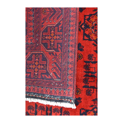 Folded-corner detail of Khal Mohammadi rug showing the reverse weave, red and dark navy front pattern and pale fringe
