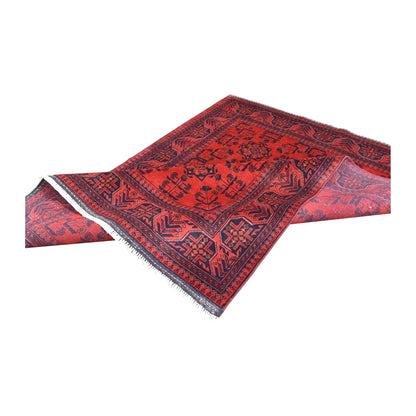 Folded view of Afghan Khal Mohammadi hand-knotted wool rug showing its red patterned pile, borders and fringe