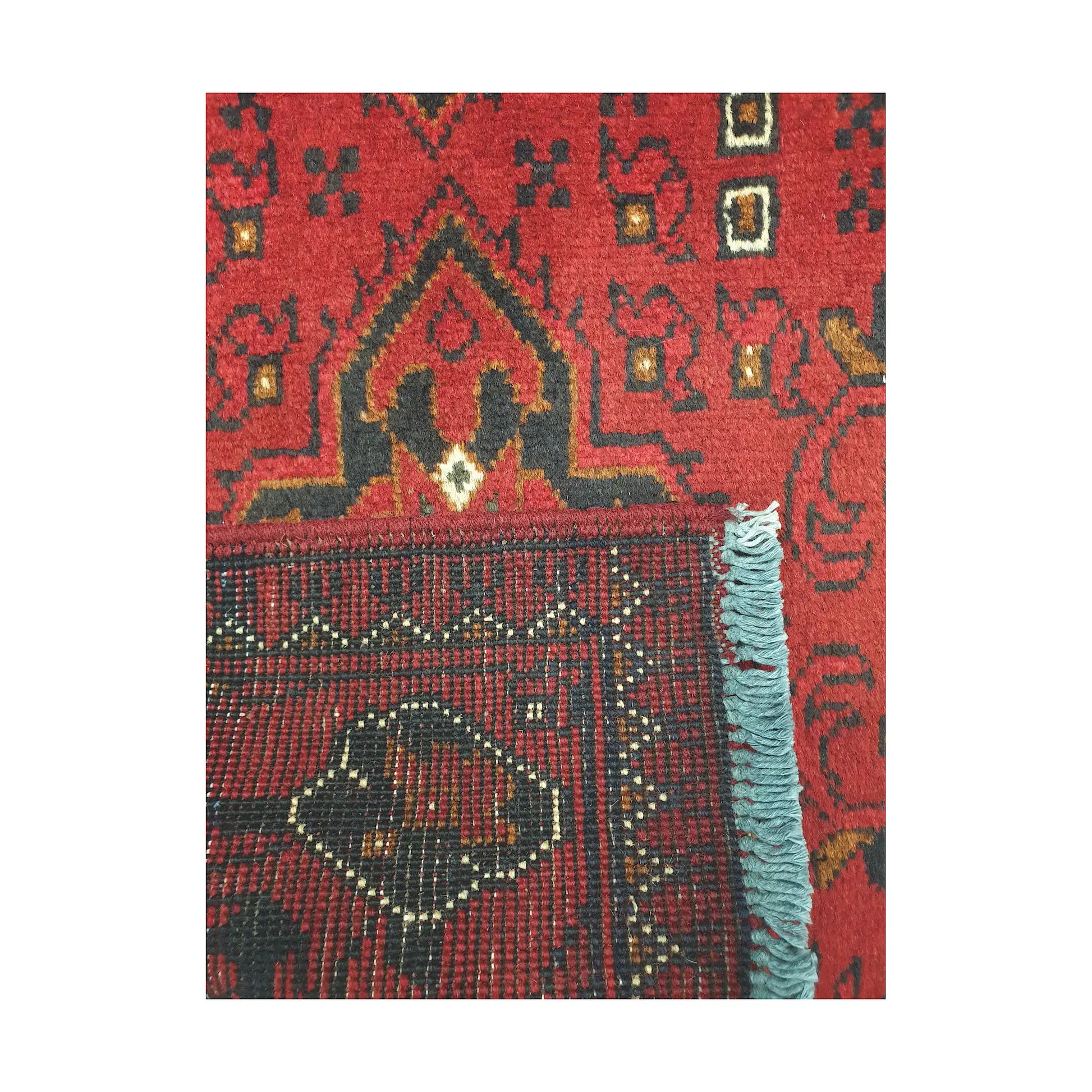 Folded corner reverse-weave detail of Afghan Khal Mohammadi hand-knotted wool rug showing back structure, red field, border pattern and weave
