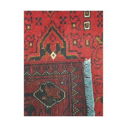Folded corner reverse-weave detail of Afghan Khal Mohammadi hand-knotted wool rug showing back structure, red field, border pattern and weave