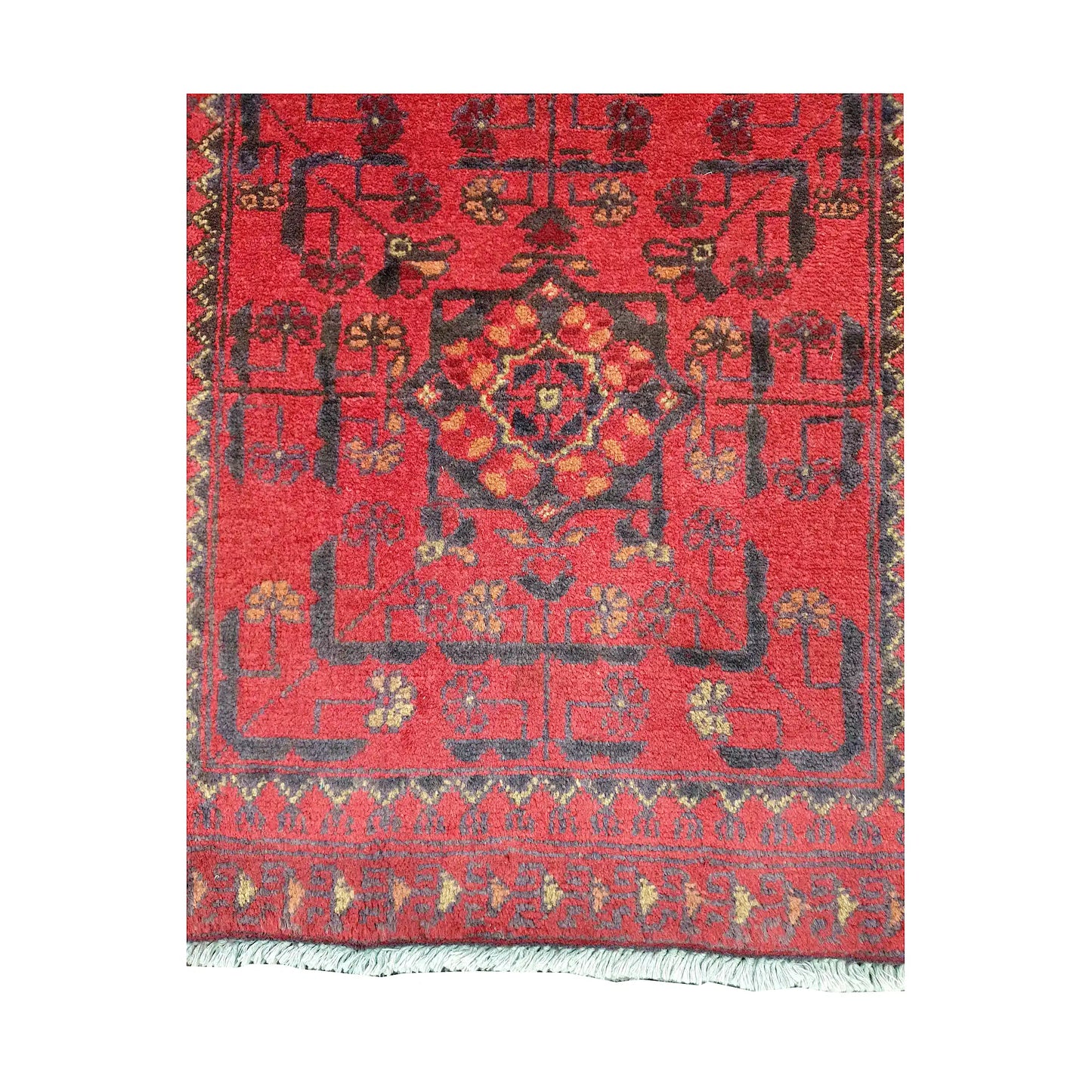 Field and border detail of Afghan Khal Mohammadi hand-knotted rug showing red ground, dark geometric motifs and patterned border