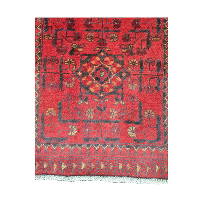 Field and border detail of Afghan Khal Mohammadi hand-knotted rug showing red ground, dark geometric motifs and patterned border