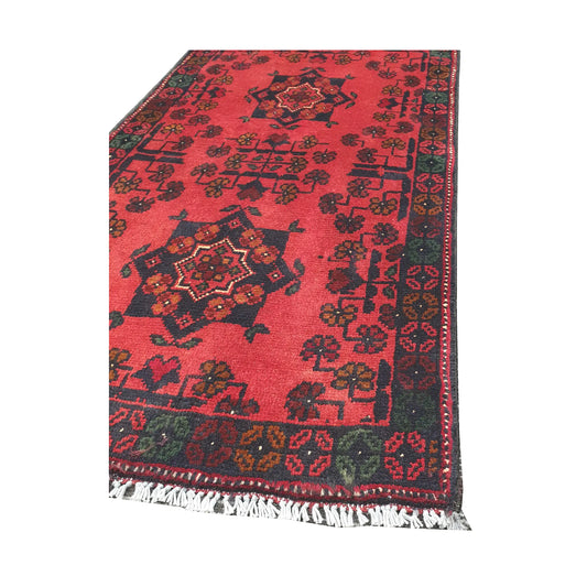 Angled corner and fringe view of Afghan Khal Mohammadi wool rug showing deep red field, dark border detail and light fringe