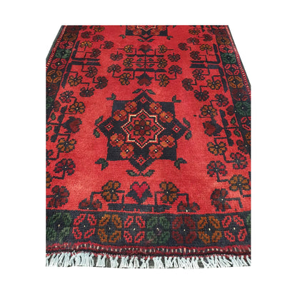 Central medallion and field detail of Afghan Khal Mohammadi hand-knotted rug showing dark geometric motifs on a deep red ground