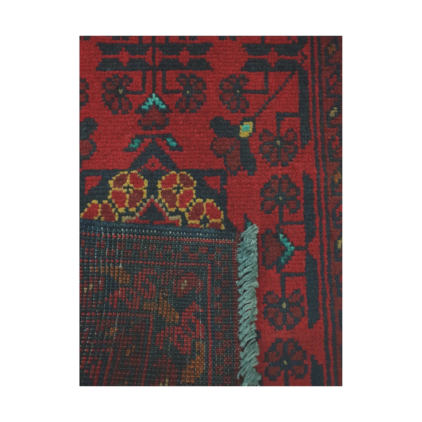 Folded corner reverse-weave detail of Afghan Khal Mohammadi hand-knotted wool rug showing back structure, fringe and border pattern