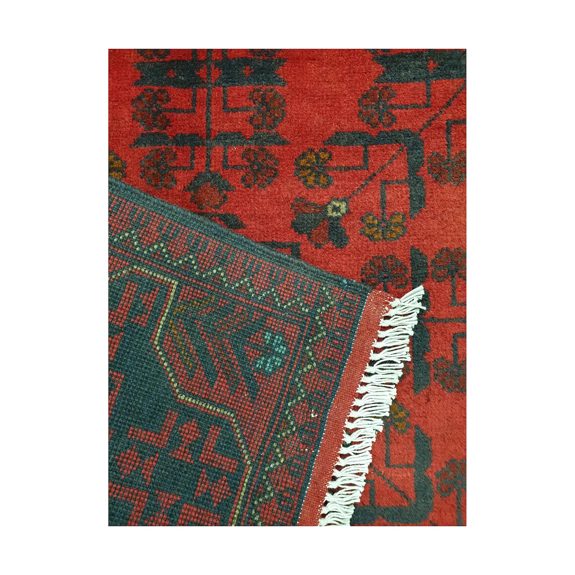 Folded corner detail of Afghan Khal Mohammadi rug showing the back of the rug, fringe and red front pattern