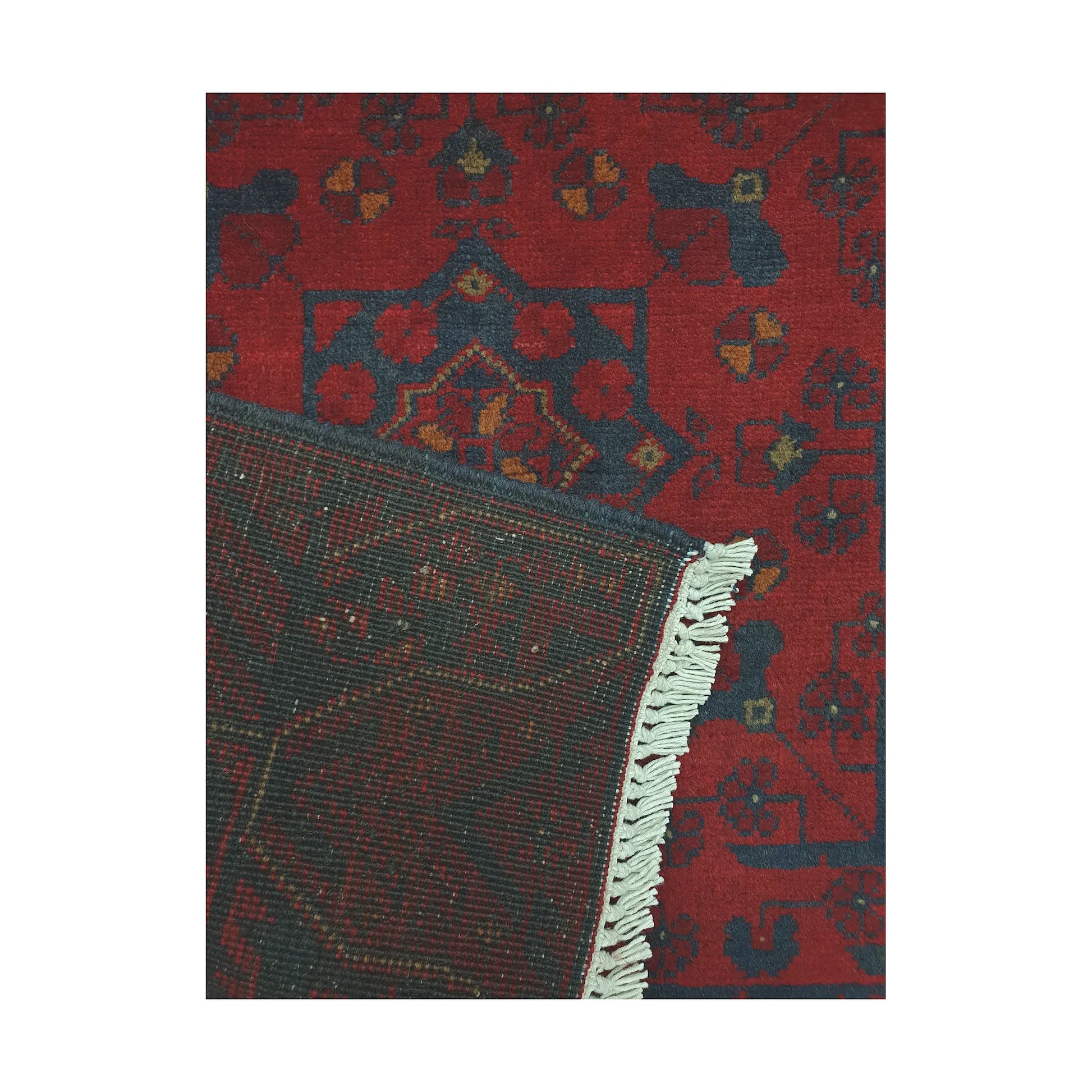 Folded corner detail of Afghan Khal Mohammadi rug showing the back of the rug, fringe and deep red front pattern