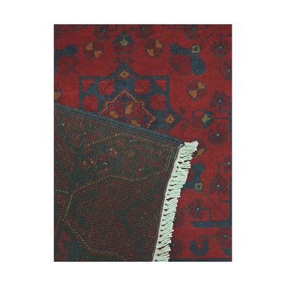 Folded corner detail of Afghan Khal Mohammadi rug showing the back of the rug, fringe and deep red front pattern