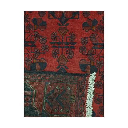 Folded corner detail of Afghan Khal Mohammadi rug showing the back of the rug, fringe and deep red front pattern