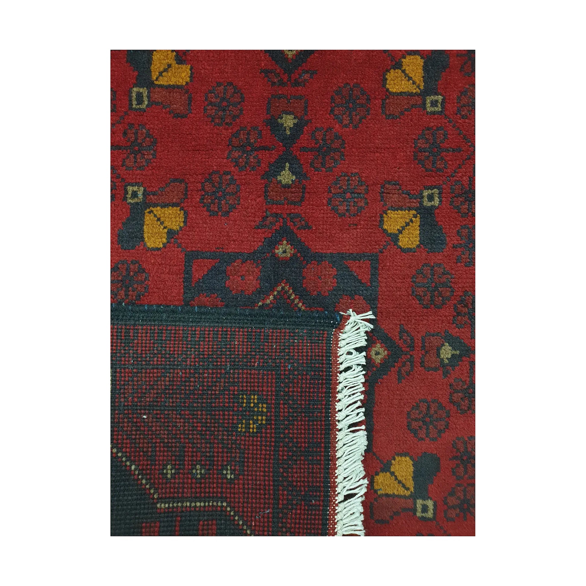 Folded corner detail of Afghan Khal Mohammadi rug showing the back of the rug, fringe and red front pattern