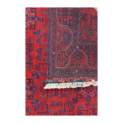 Folded-corner detail of Afghan Khal Mohammadi rug showing the patterned reverse beside its red floral front and ivory fringe