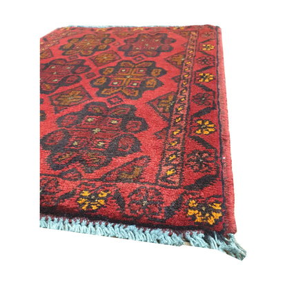 Fringe and border detail of Afghan Khal Mohammadi wool rug showing red field, dark edging and small tribal motifs