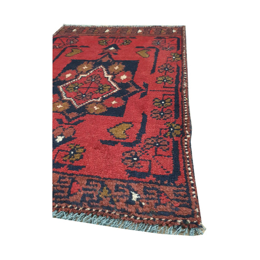 Fringe and border detail of Afghan Khal Mohammadi wool rug showing red field, dark edging and tribal motifs