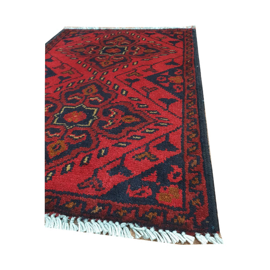 Angled fringe and border detail of Afghan Khal Mohammadi wool rug showing red pile and dark geometric edging