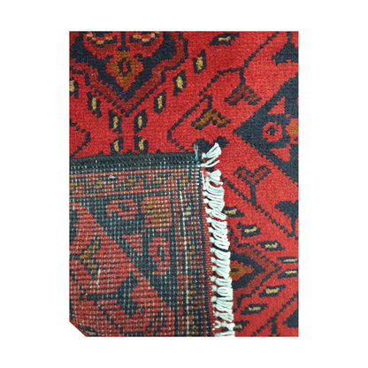 Folded corner detail of Afghan Khal Mohammadi wool rug showing the back, fringe and red front pattern
